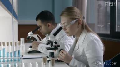 集中的女科学家研究员和她的年轻男同事在<strong>实验室</strong>进行实验的专业团队使用显微镜和分享
